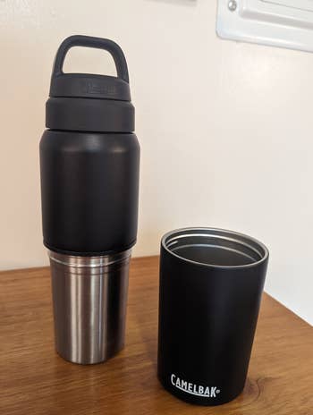 a reviewer photo of the same bottle with the travel cup sitting next to it 