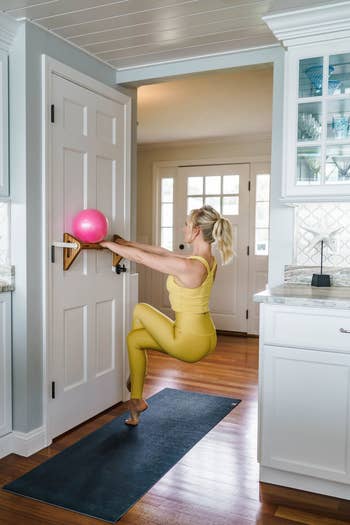 person using barre attached to the door to do exercises