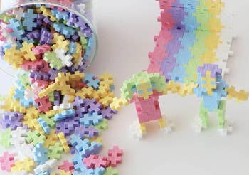 Toy operation  blocks successful  assorted  pastel colors spilling from a container, with figures made from these blocks displayed connected  a surface
