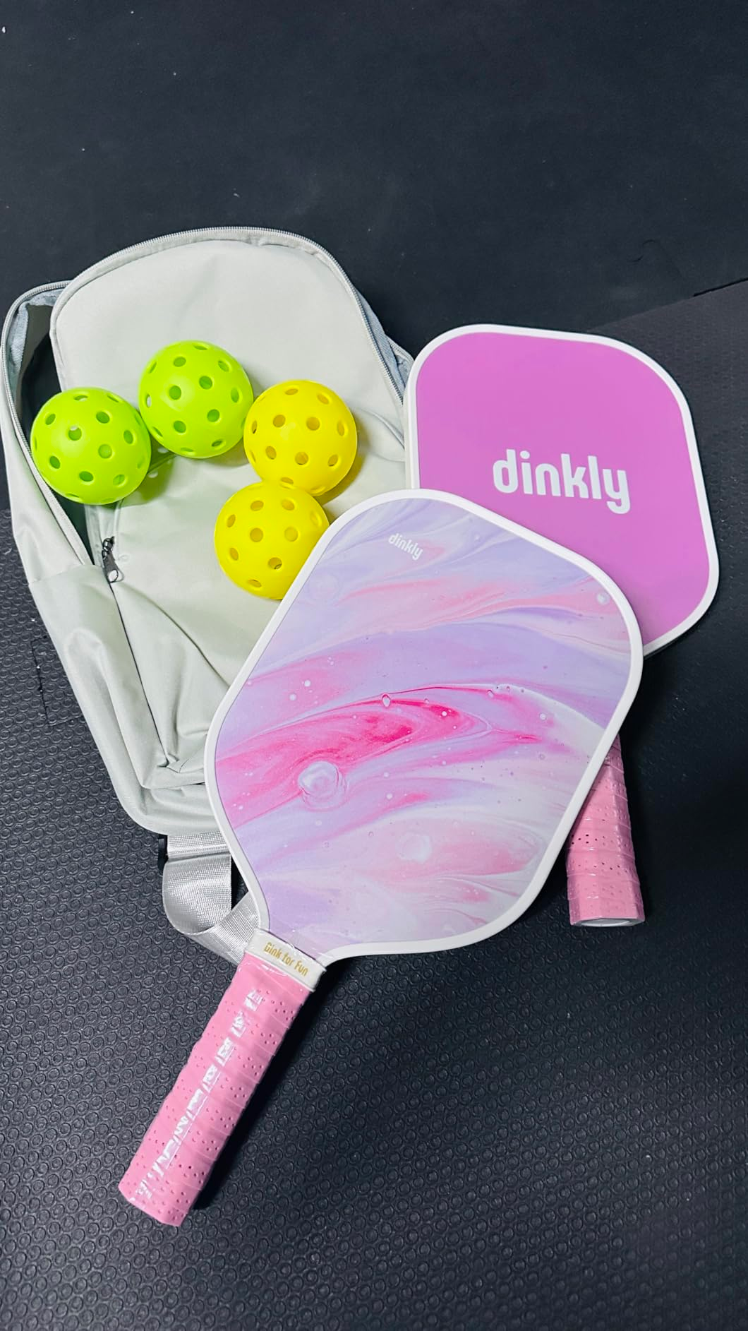 two paddles successful  a marble pinkish  plan  adjacent  to 4  balls and a carrying bag