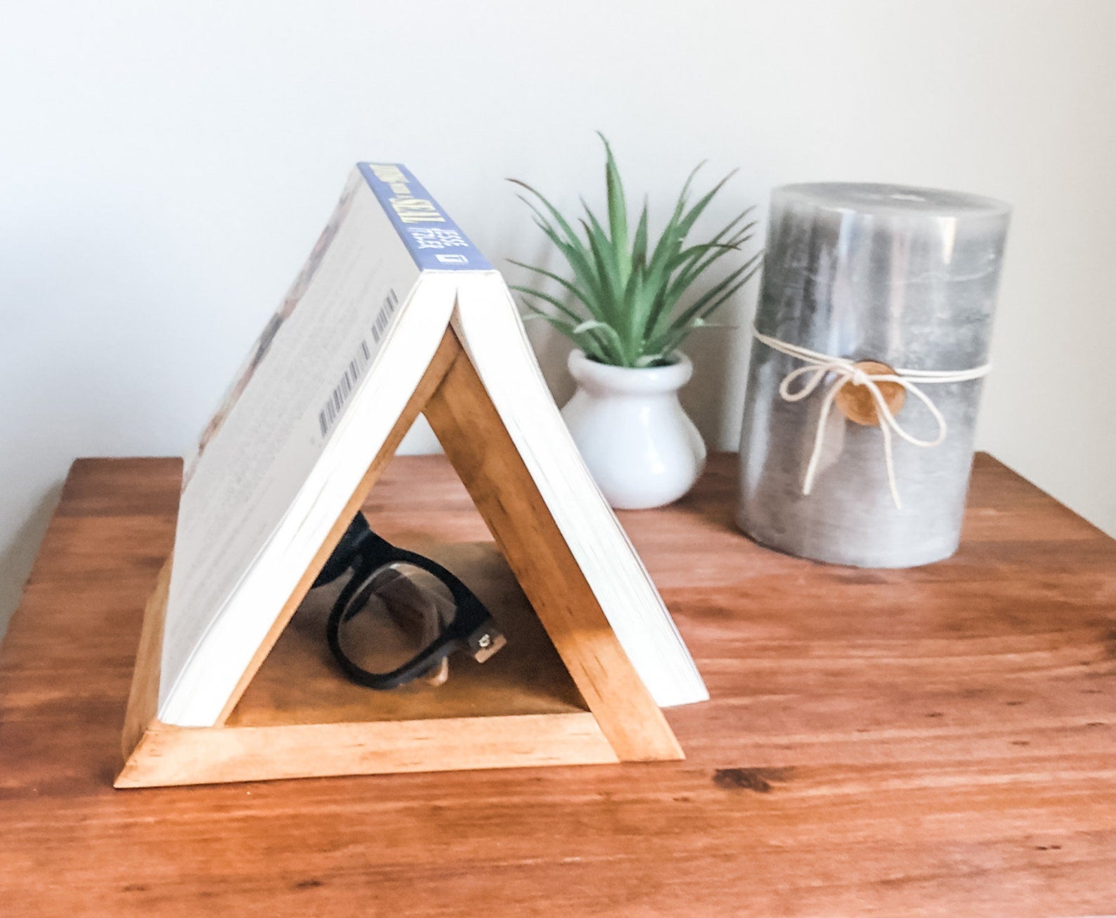 lifestyle photo of book upside down on book stand on a nightstand