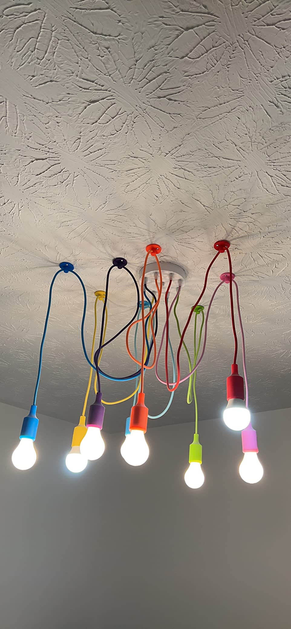 Ceiling-mounted lighting fixture with colorful cords and exposed bulbs, creator  and modern   design
