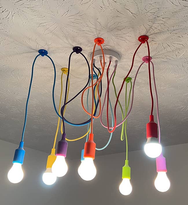 Ceiling-mounted lighting fixture with colorful cords and exposed bulbs, creator and modern design