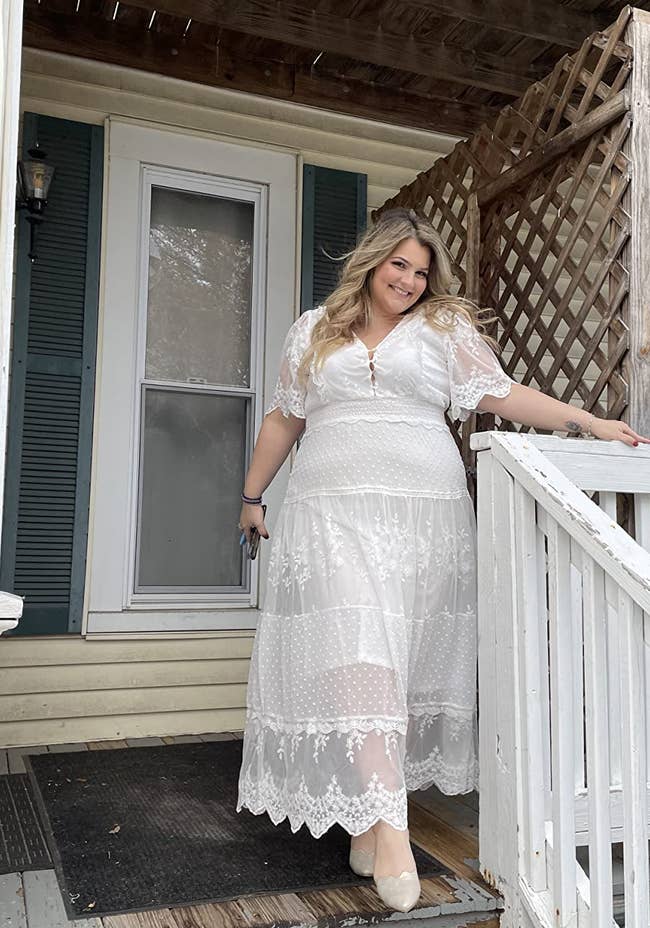 A reviewer posing in the white lace dress