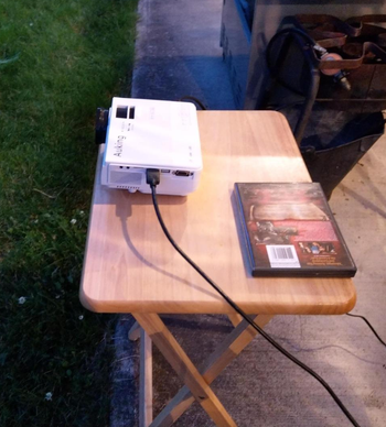 reviewer photo of the small projector on an outdoor table