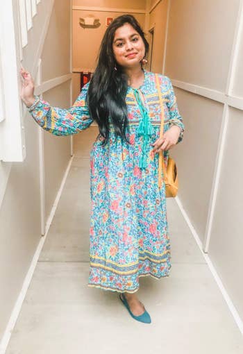 reviewer in the long sleeve aqua, yellow, and pink print maxi dress with tassel detail