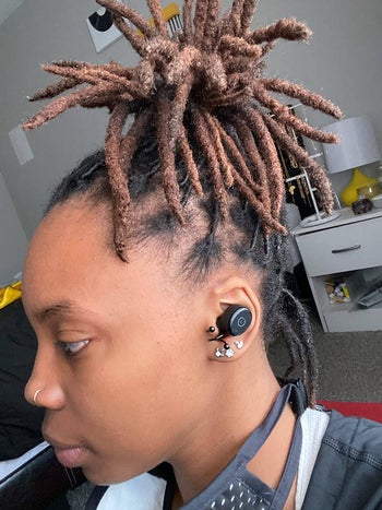 The reviewer wearing the ear buds