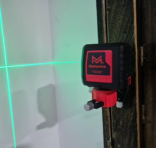 reviewer's tool mounted on a wall and projecting two lines onto a wall