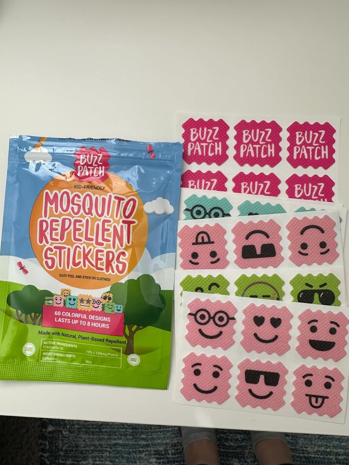 BuzzPatch Mosquito Repellent Stickers packaging and respective  sticker sheets with colorful, playful designs, specified  arsenic  animals and smiley faces
