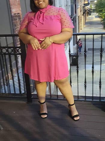 reviewer wearing the pink dress with black heels