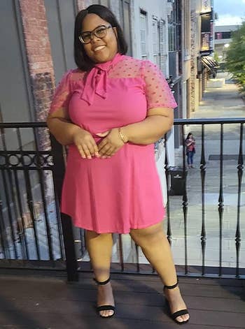 reviewer wearing the pink dress with black heels