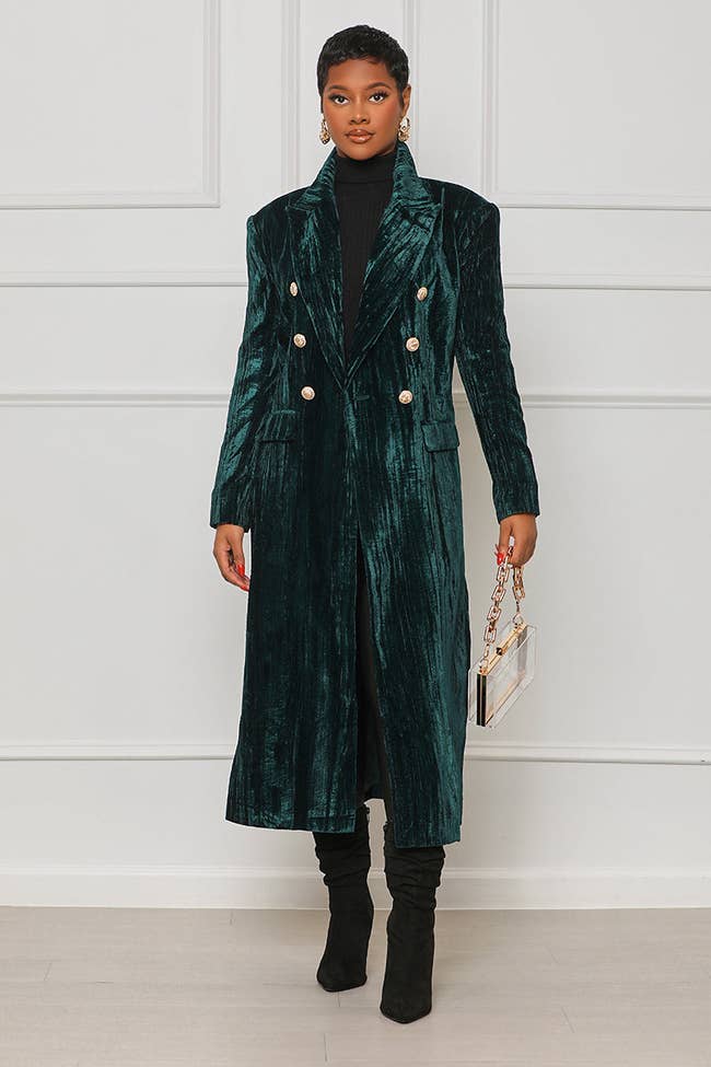 model in long green crushed velvet coat with gold buttons