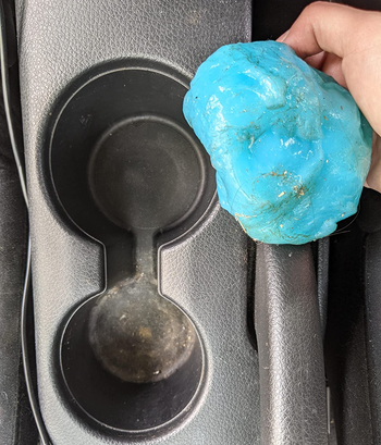 different reviewer showing the blue cleaning gel covered with grime that was inside of a car's cup holder