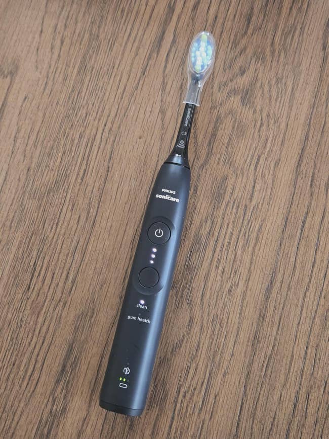 Electric toothbrush with a integer  show  and aggregate  cleaning modes, placed connected  a woody  surface