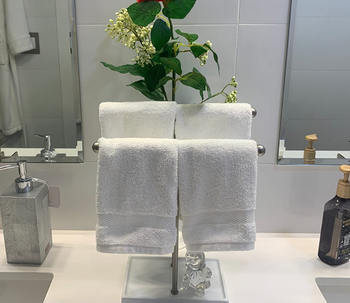 Reviewer pic of the same holder with four white towels displayed on it