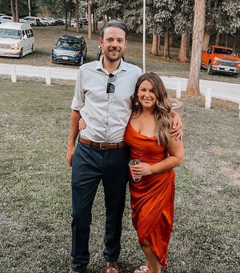 reviewer posing with friend wearing burnt orange colored satin dress