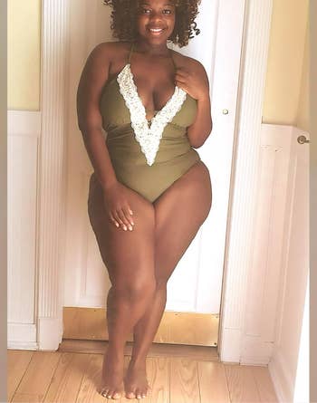 Reviewer wearing the olive plunging one-piece with strappy details across the chest and white crochet