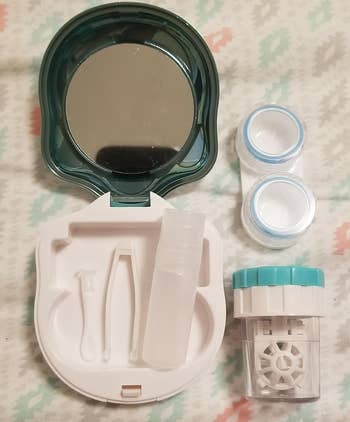 Contact lens travel kit with mirror, lens case, tweezers, solution bottle, and a lens holder