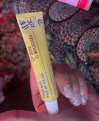 A reviewer holding the eye cream