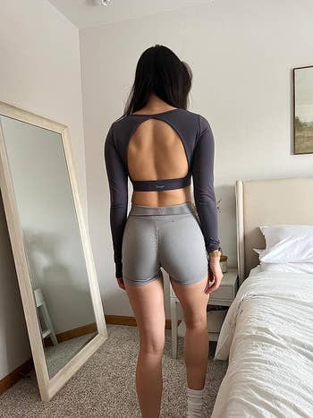 The same reviewer wearing the purple sports bra and showing the open back feature