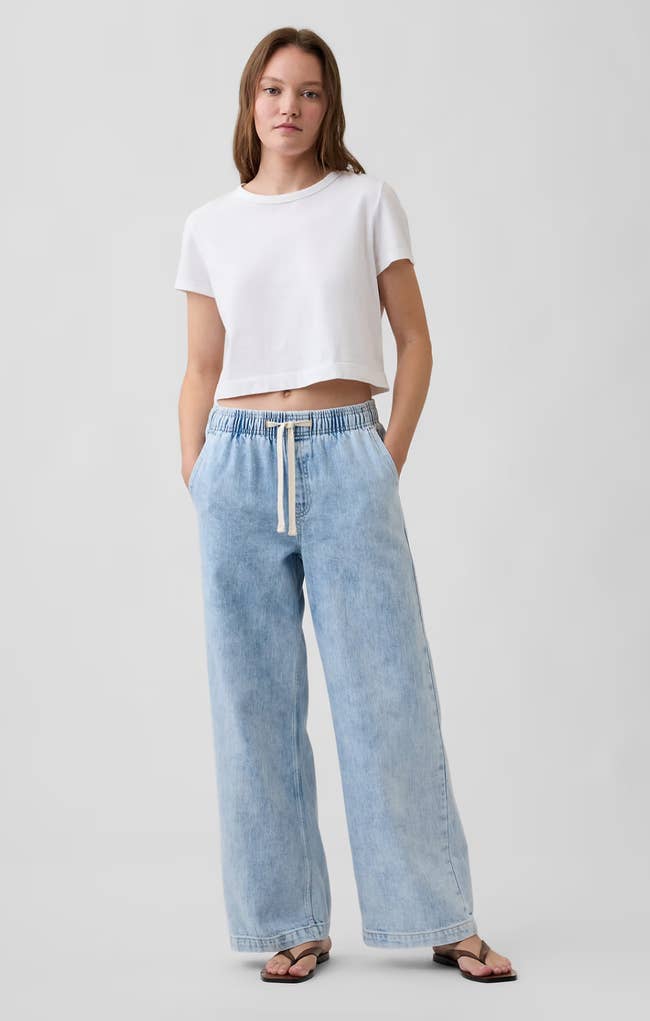 Person successful  a casual achromatic  harvest  apical  and loose-fitting airy  lavation  jeans with drawstring, lasting  successful  a relaxed pose