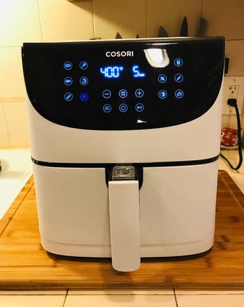 Reviewer pic of a white square shaped air fryer with a digital control panel 