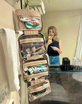 the toiletry bag hanging in a bathroom, with the writer in the background