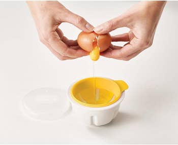 Hands crack an egg into a yolk separator over a tiny bowl