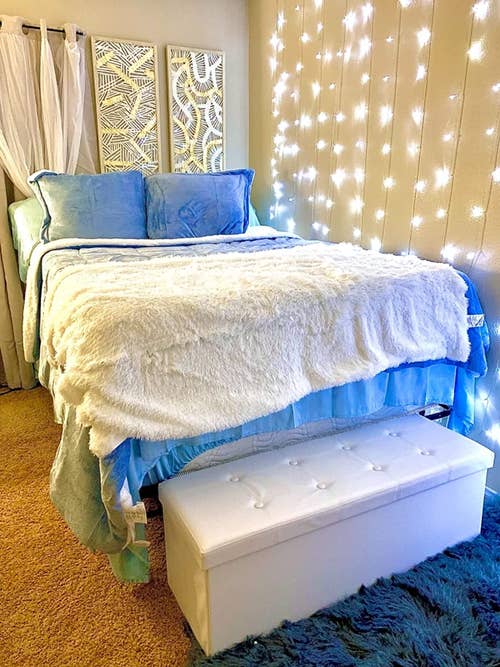 reviewer photo of white storage ottoman at the foot of bed