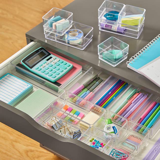 the clear drawer organizers used in an office holding various supplies