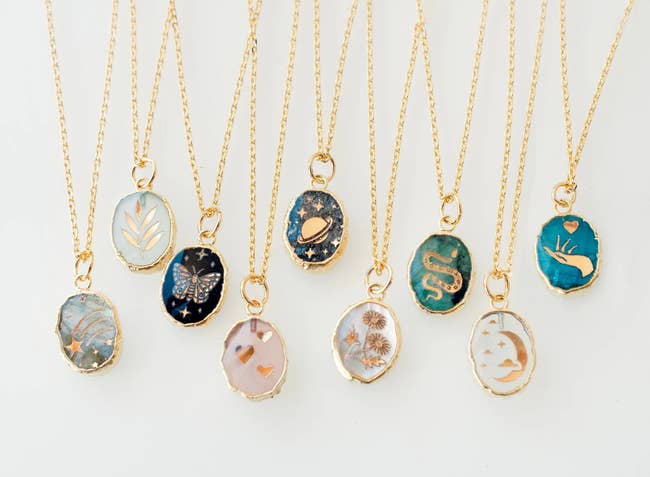 nine gemstone pendant necklaces with gold chains and different symbols on them