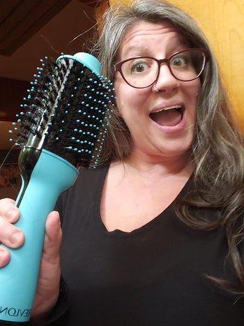 reviewer holding up a blue revlon brush