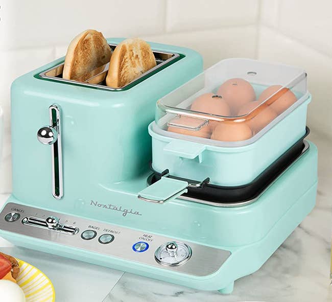 Blue toaster with two slots and a side with a grill and an egg cooker 