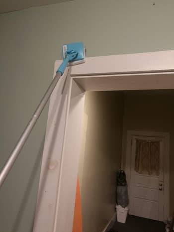 a antithetic  reviewer utilizing the instrumentality   to cleanable  the apical  of a doorway  frame
