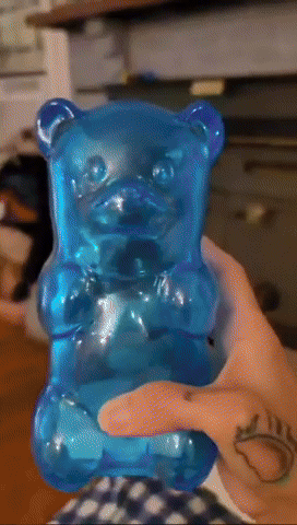 Hand holding a large, transparent blue gummy bear toy