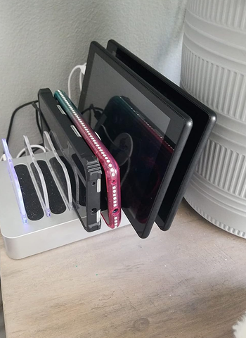 reviewer's charging stand with various devices in it
