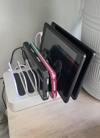 reviewer's charging stand with various devices in it
