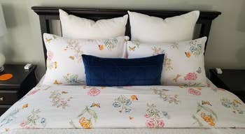 reviewers bed with pink floral print sheets on it