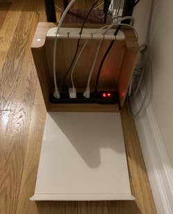Cords plugged into power strip and placed inside organizer box