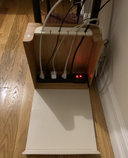 Cords plugged into power strip and placed inside organizer box