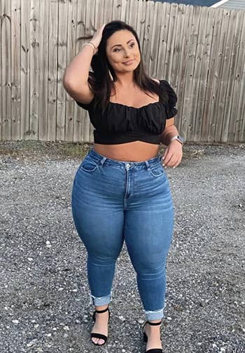 reviewer wearing the black top with jeans and black heels