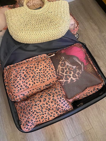 A reviewer's luggage filled with the packing cubes