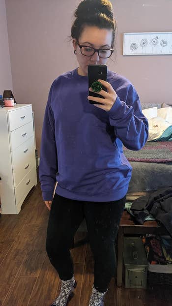 reviewer wearing purple crewneck