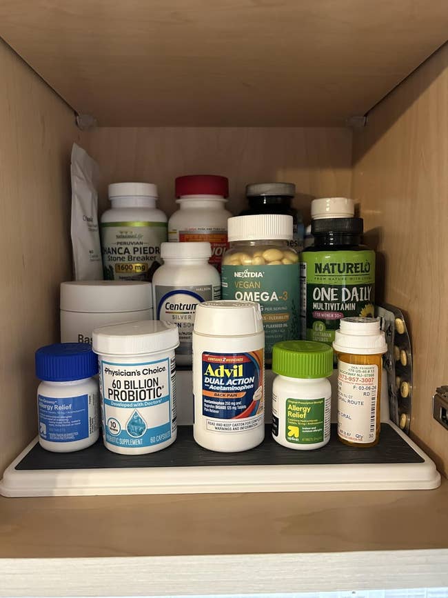 A furniture  filled with assorted  vitamin and supplement bottles, including probiotics, multivitamins, allergy relief, and symptom  relievers