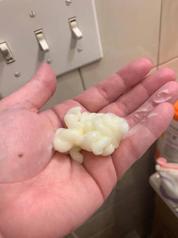 a reviewer with a pile of the conditioner in their palm