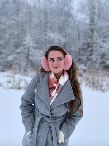 reviewer posing wearing pink ear muffs