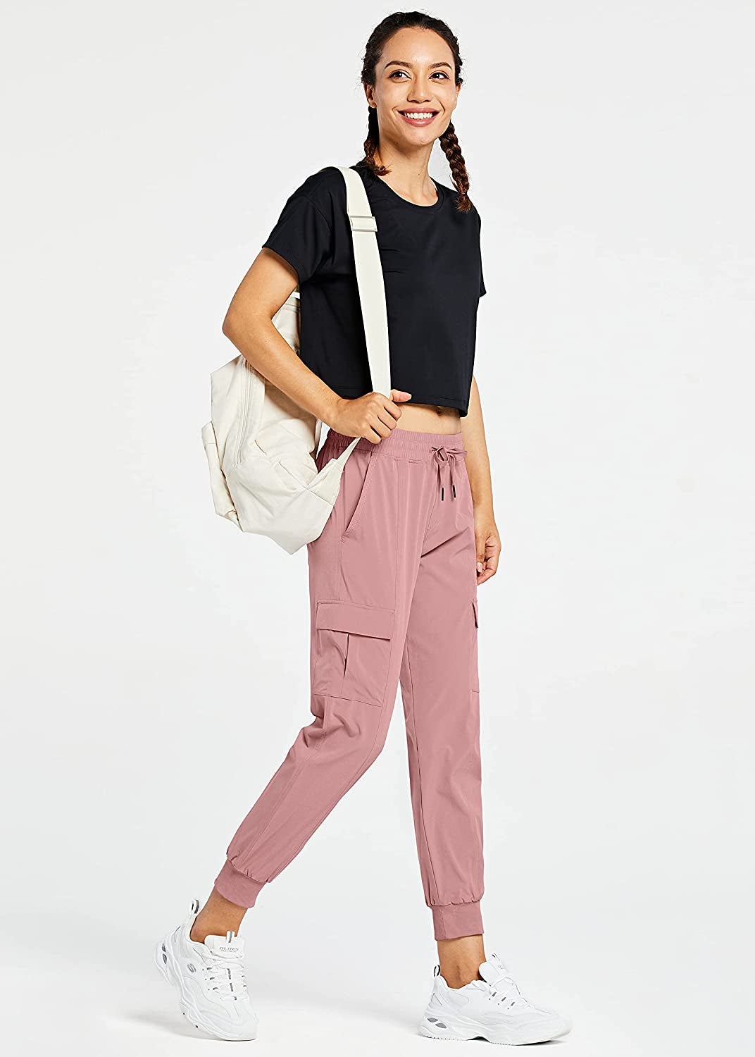 model wearing the pink joggers with a black tee and white sneakers