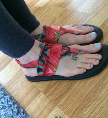 reviewer wearing the red sling sandals