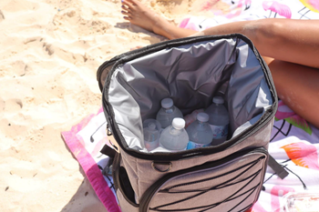 reviewer showing the inside of the cooler at the beach filled with water bottles