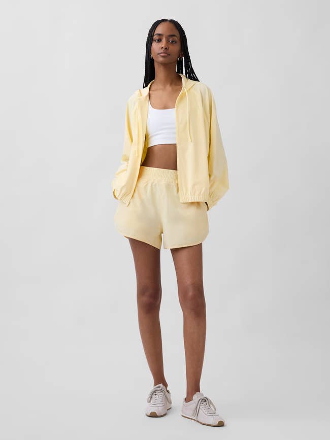 Person wearing a casual shorts acceptable with a achromatic harvest top, hands successful pockets